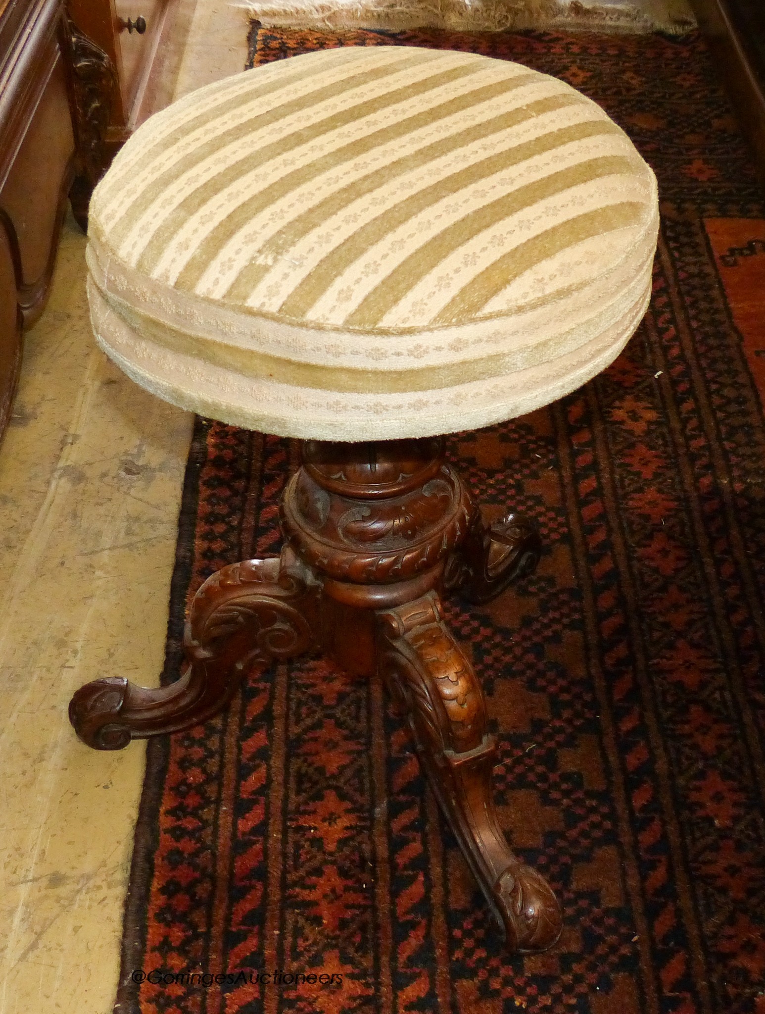 A Victorian walnut revolving piano stool.